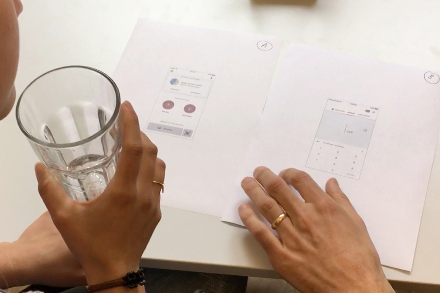 Paper prototypes for user testing, showing marked app variants A and B on a table.