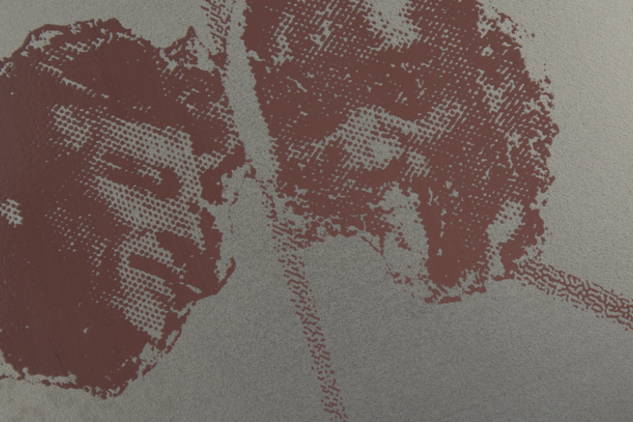 Extreme close-up of a screen print on gray metal sheet showing the fine grid pattern of two brown printed faces.