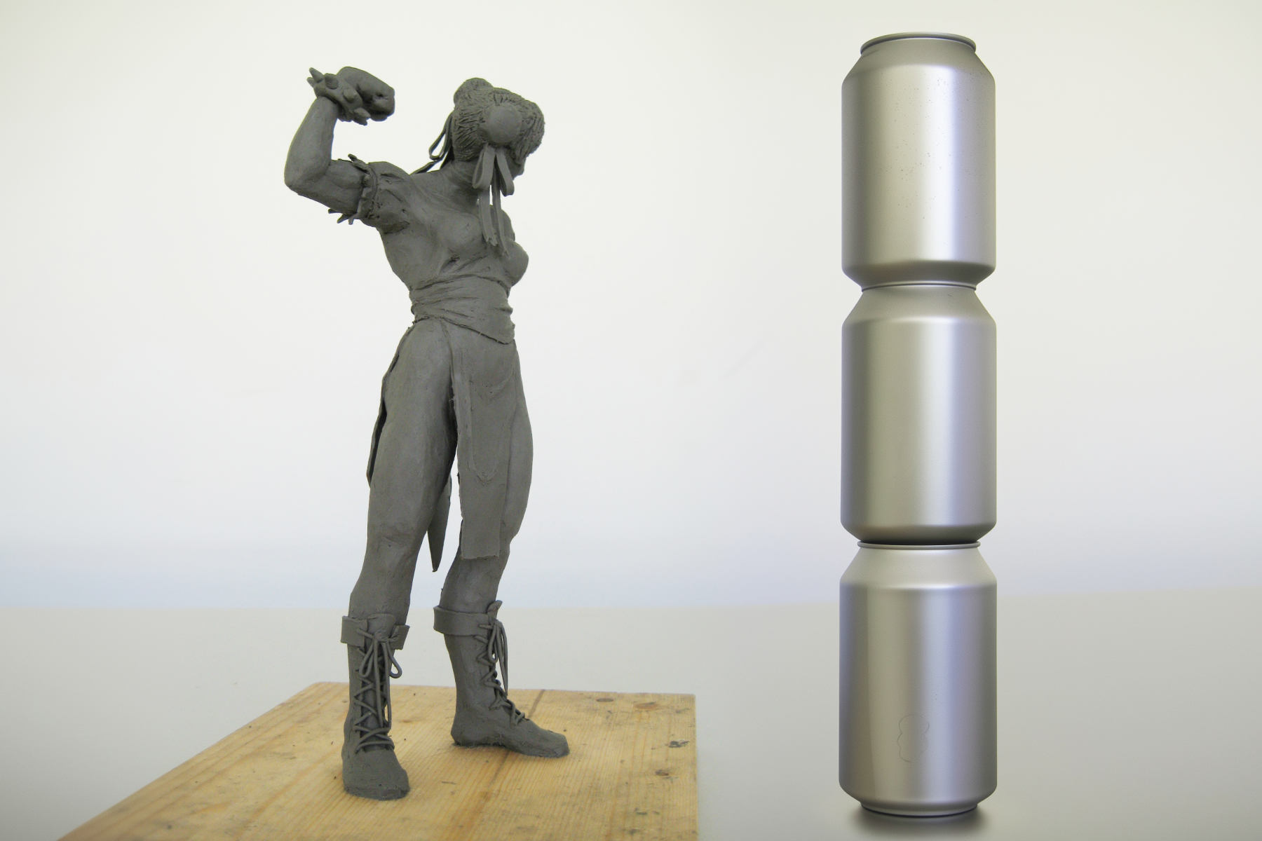 Size comparison of the Chun-Li plasticine sculpture next to three beverage cans stacked on top of each other.